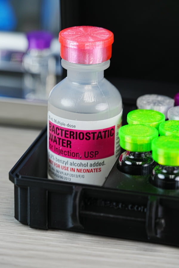 Order bacteriostatic water online — Hospira 30 mL BAC water USP bottle nested in a hard-shell VialCase organizer beside neatly capped peptide vials